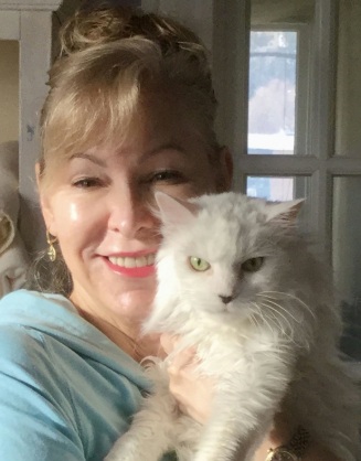 Deborah Felin Magaldi smiling with a cat in her arms.